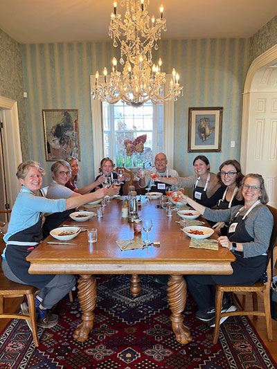 Half-Day Group Cooking Class  - Corporate - A bunch of people sitting at wooden table toasting